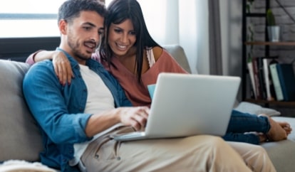 Couple on couch on computer